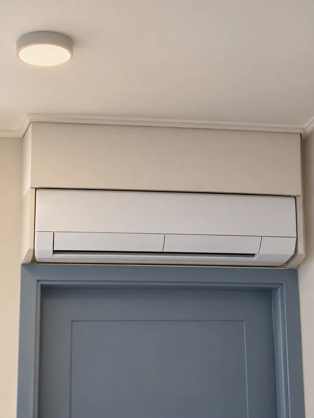 Exempel på en luftvärmepumps innedel som byggts in för tätt ovanför en dörr